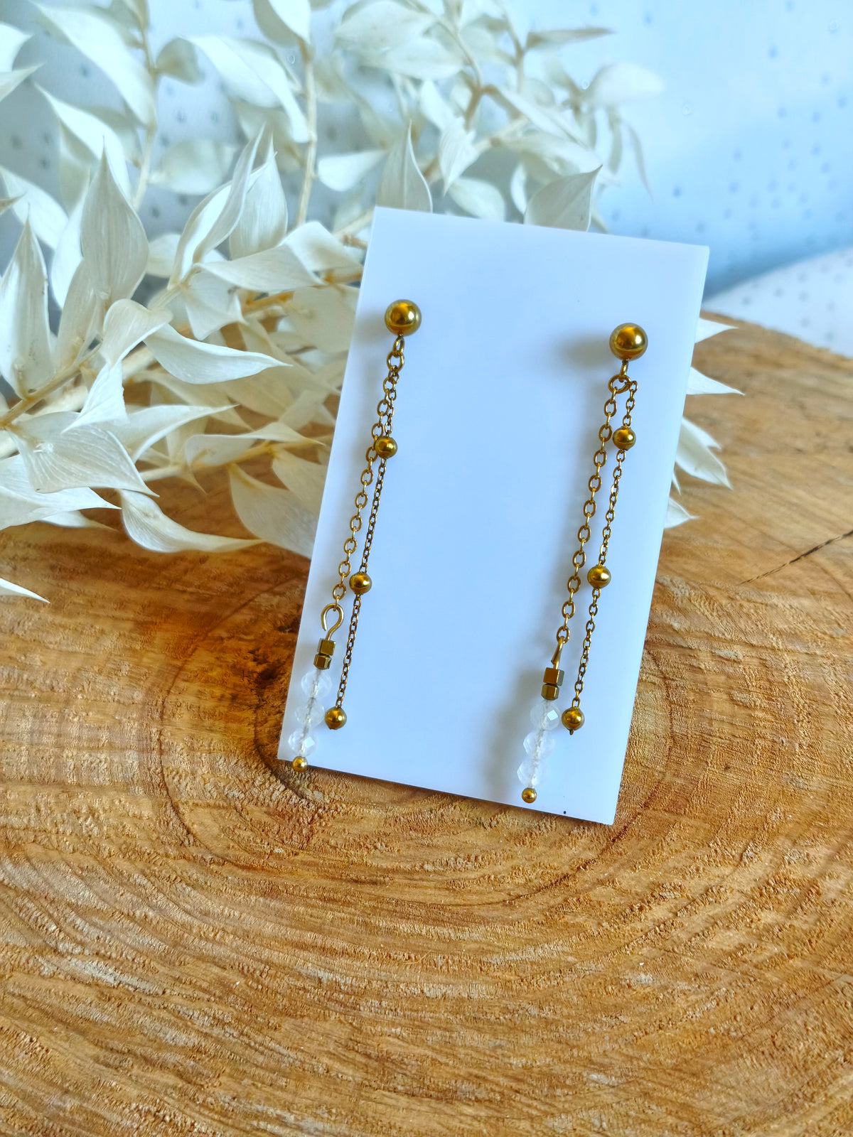 Une paire de boucles d'oreilles très fines accompagnée de peristerite la fameuse labradorite blanche