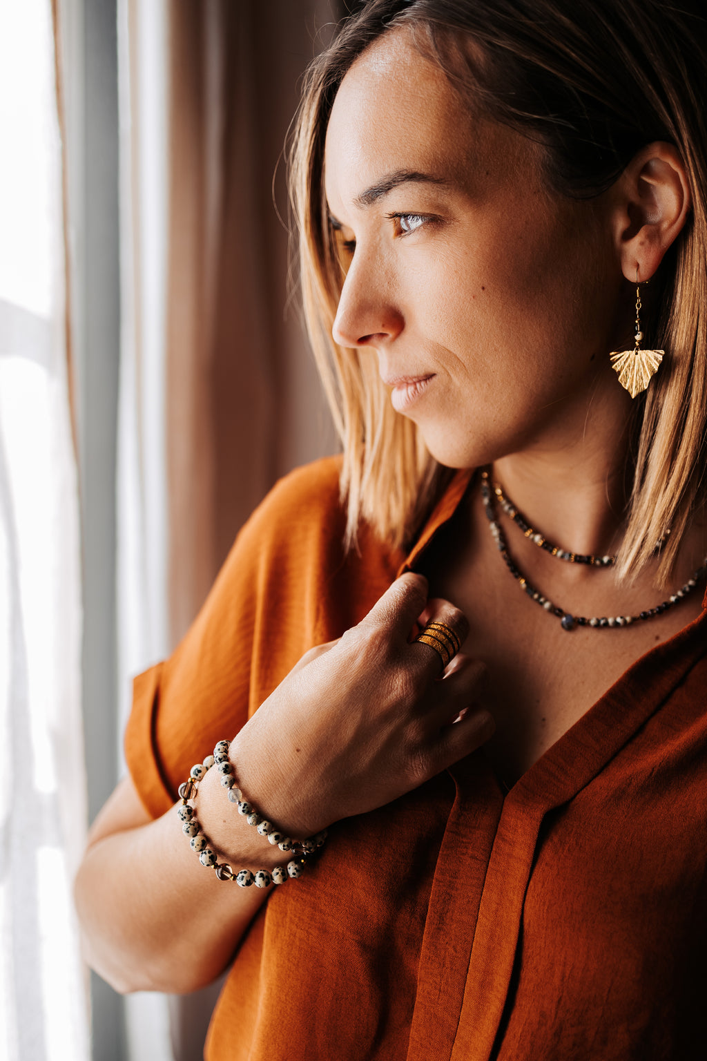 Laurine porte un ensemble de bijoux en jaspe dalmatien et quartz fumer