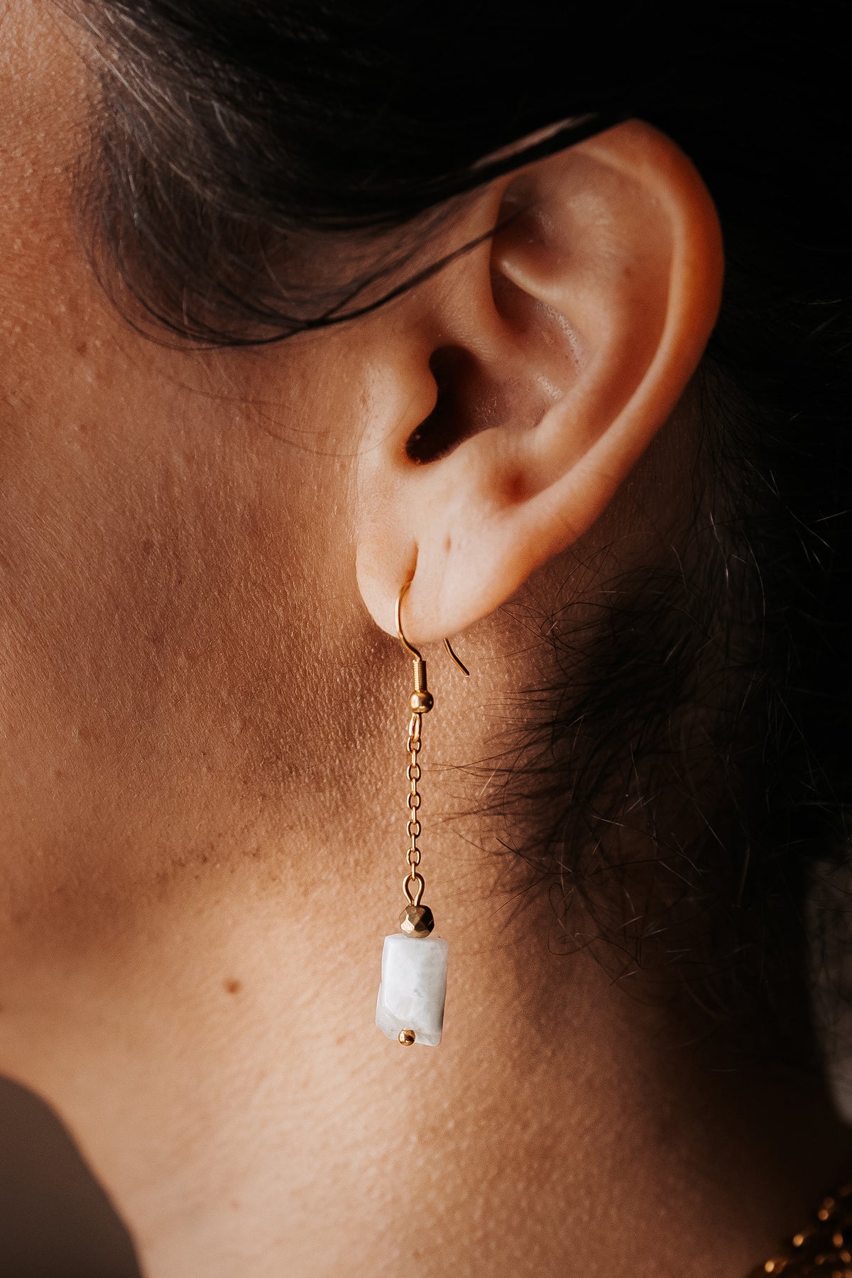 Notre modèle porte merveilleusement bien les boucles d'oreilles en peristerite 